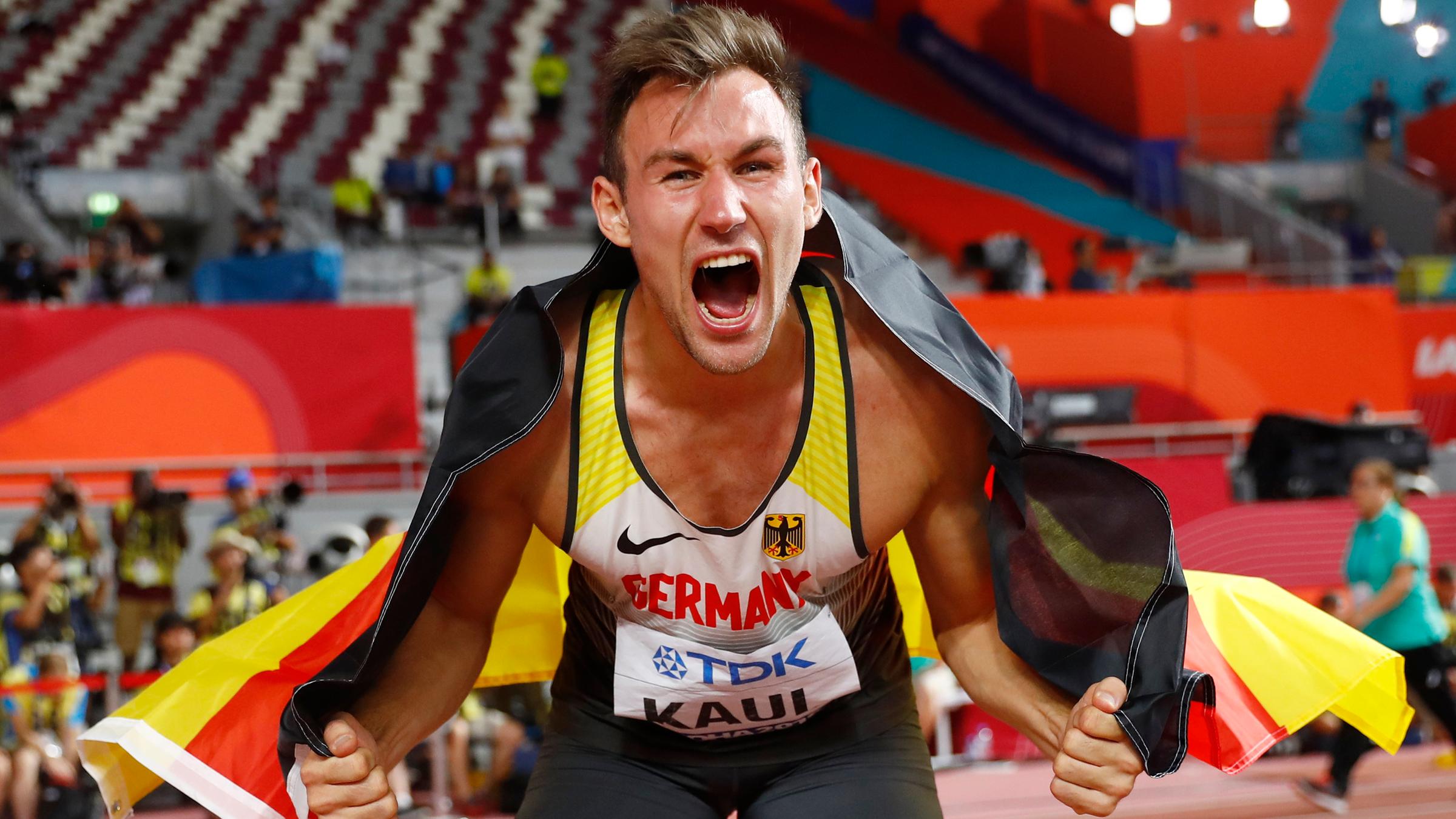 Niklas Kaul jubelt mit einer Deutschlandfahne. 