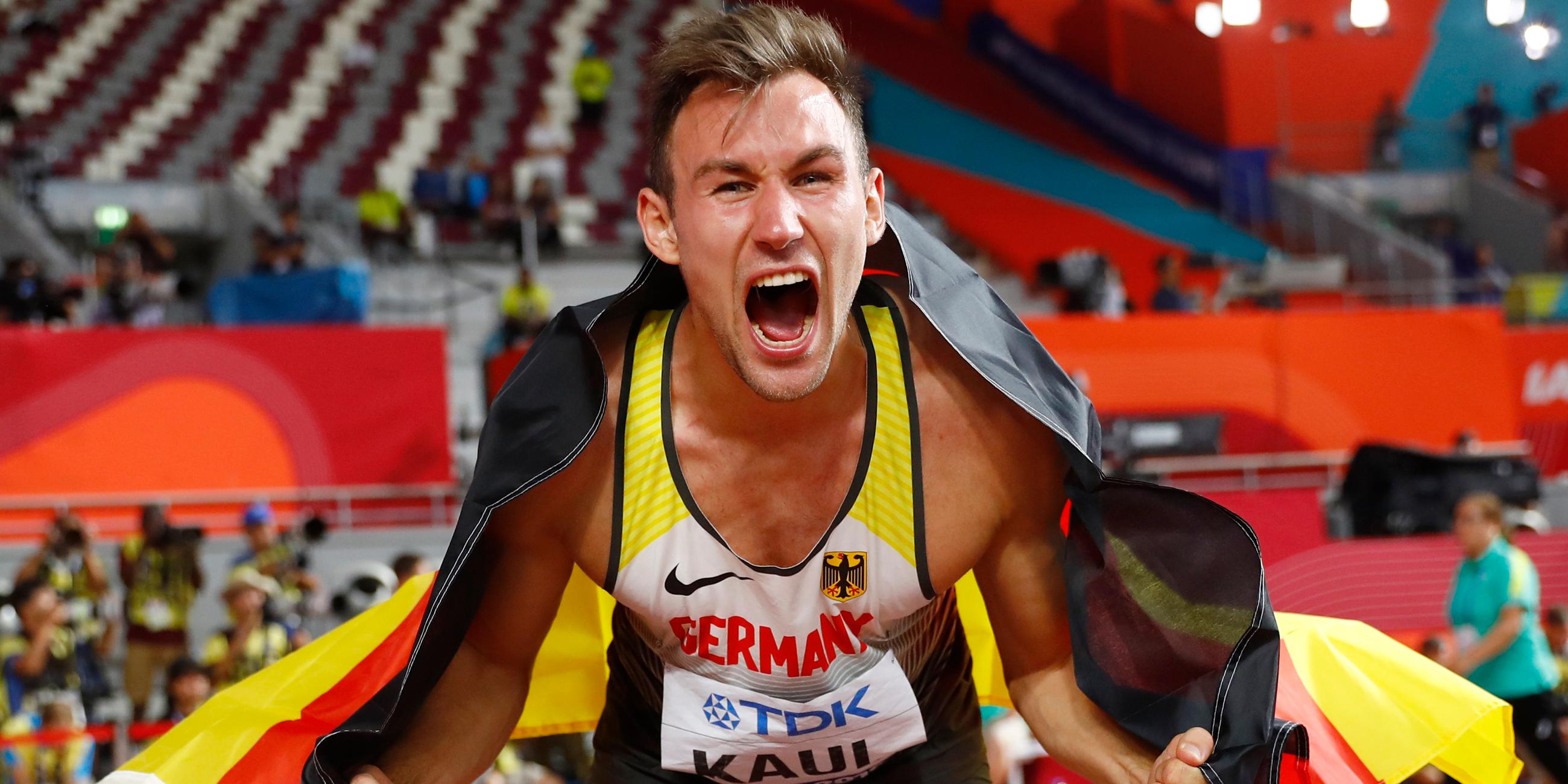 Niklas Kaul jubelt mit einer Deutschlandfahne. 