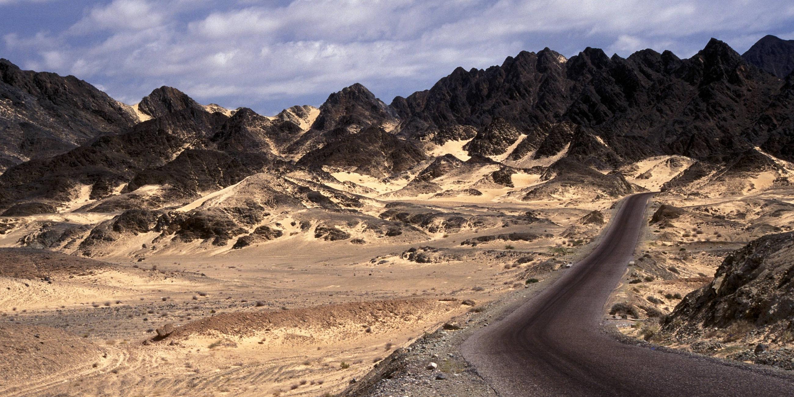Straße im Jemen führt durch Vulkangestein und Sand