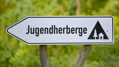 Ein Schild weist auf eine Jugendherberge hin.