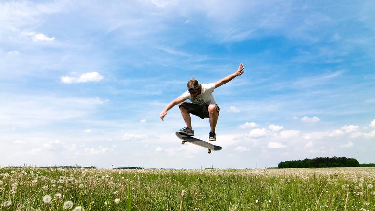 Ein Junge macht einen Trick auf dem Skateboard