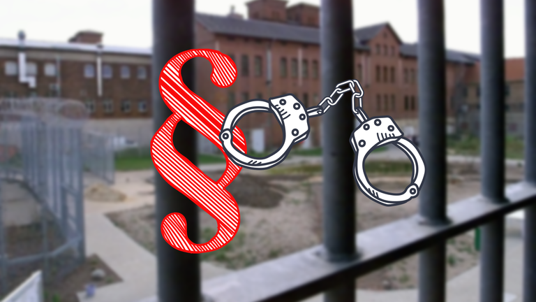 Gitterstäbe eines Gefängnisses, davor Handschellen und ein Paragraphenzeichen