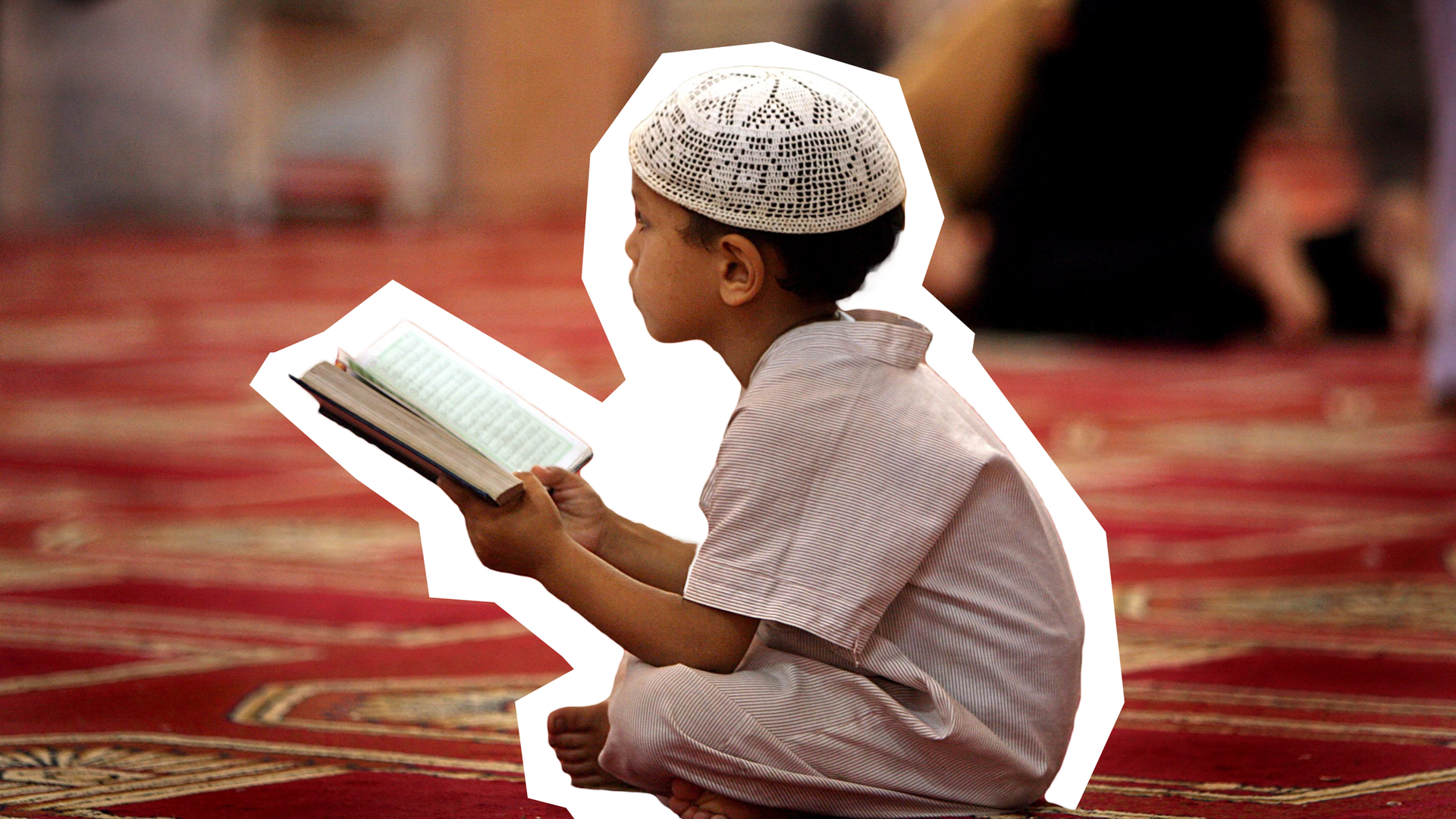 Ein Junge sitzt auf dem Boden und liest den Koran.