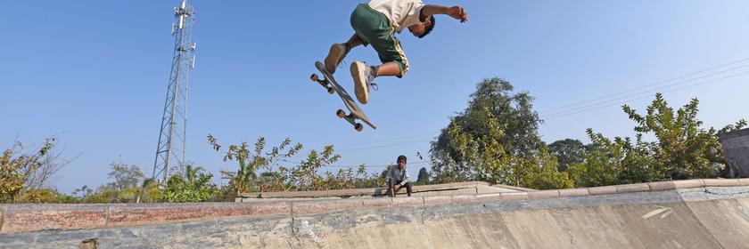 Ein Junge macht Tricks auf einem Skateboard in Indien