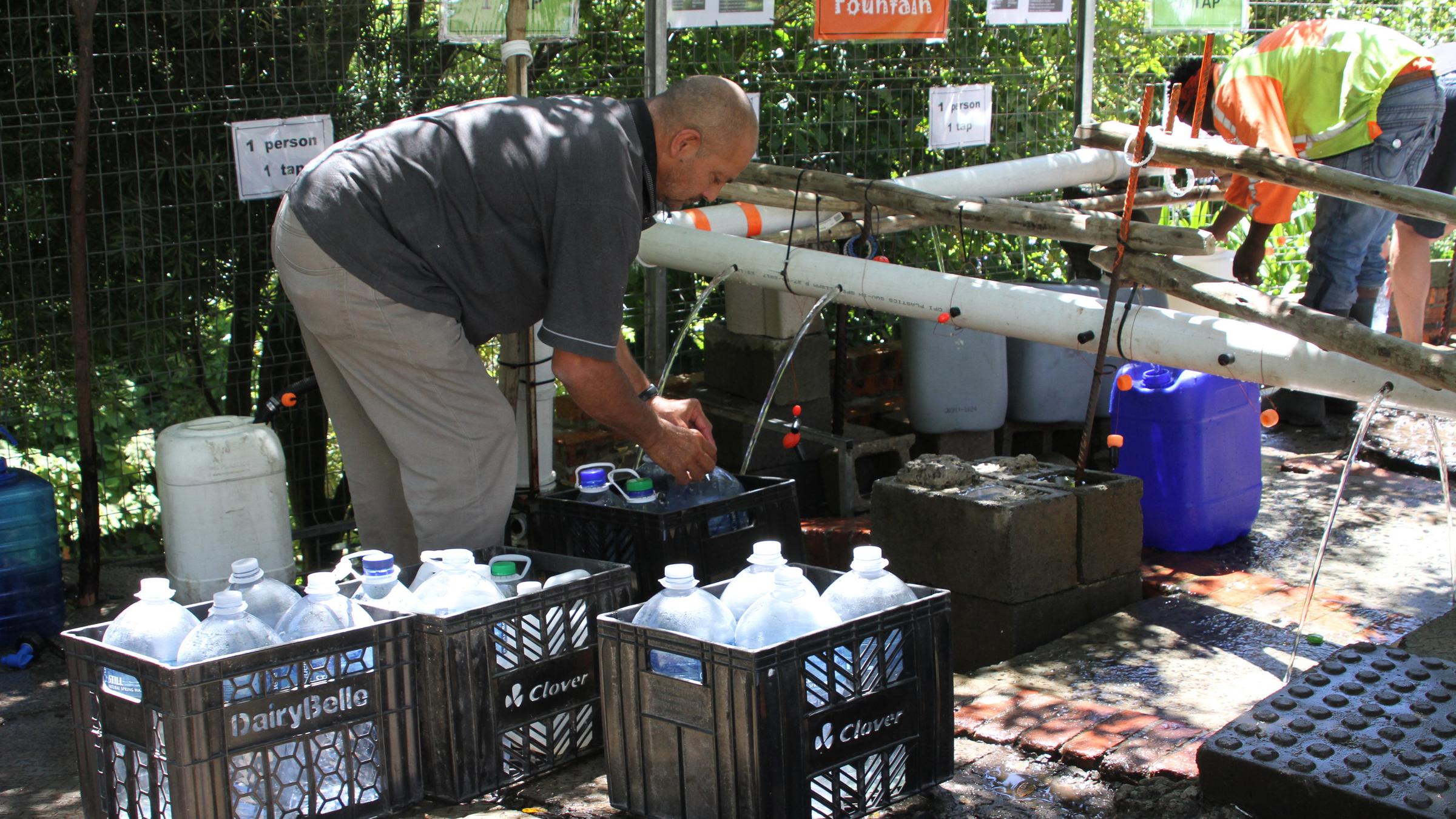 Bürger füllen Wasserkanister an einer natürlichen Quelle in Newlands, Kapstadt