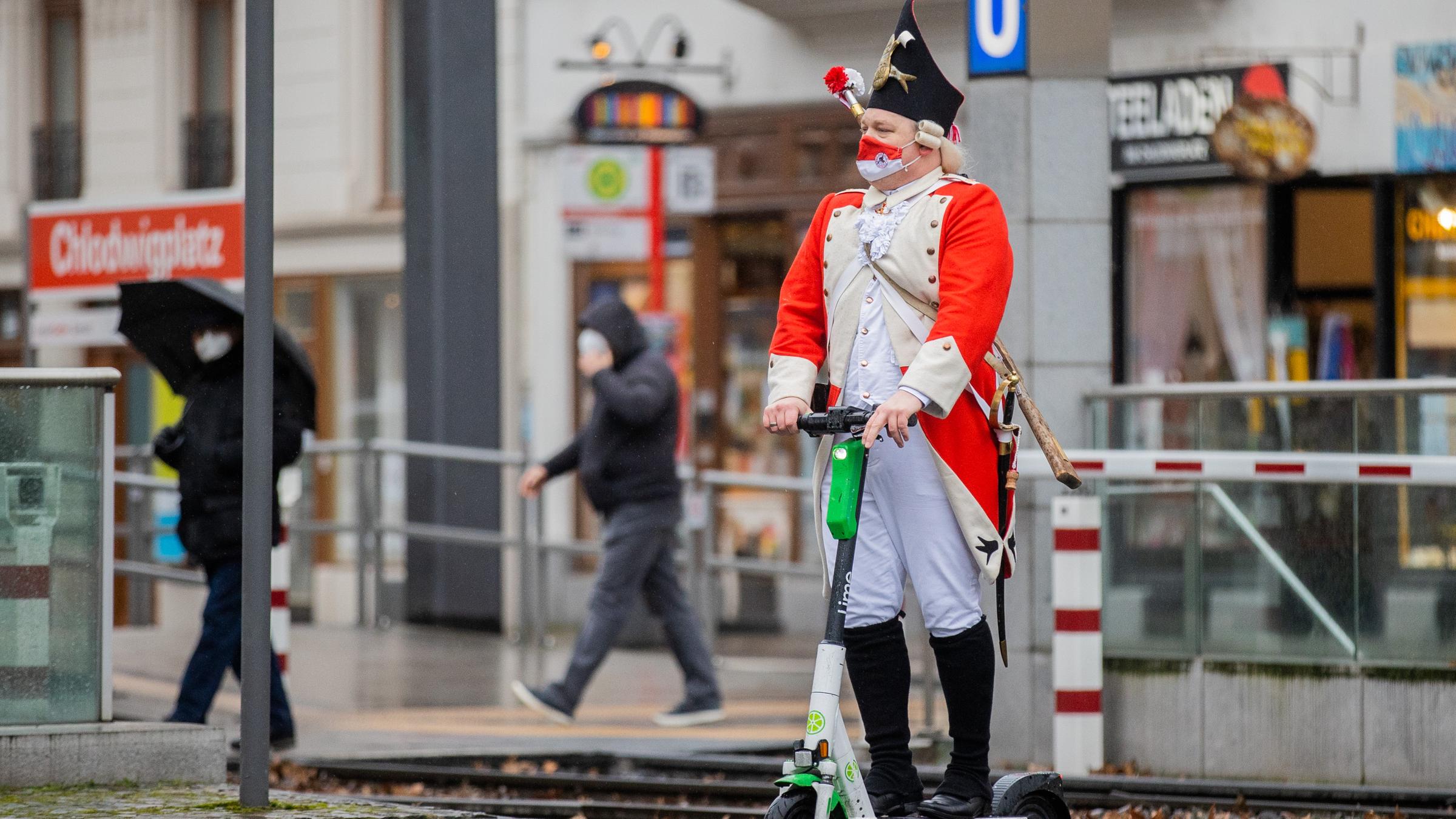 Ein Mann mit roter Pappnase läuft vor dem Kölner Dom.