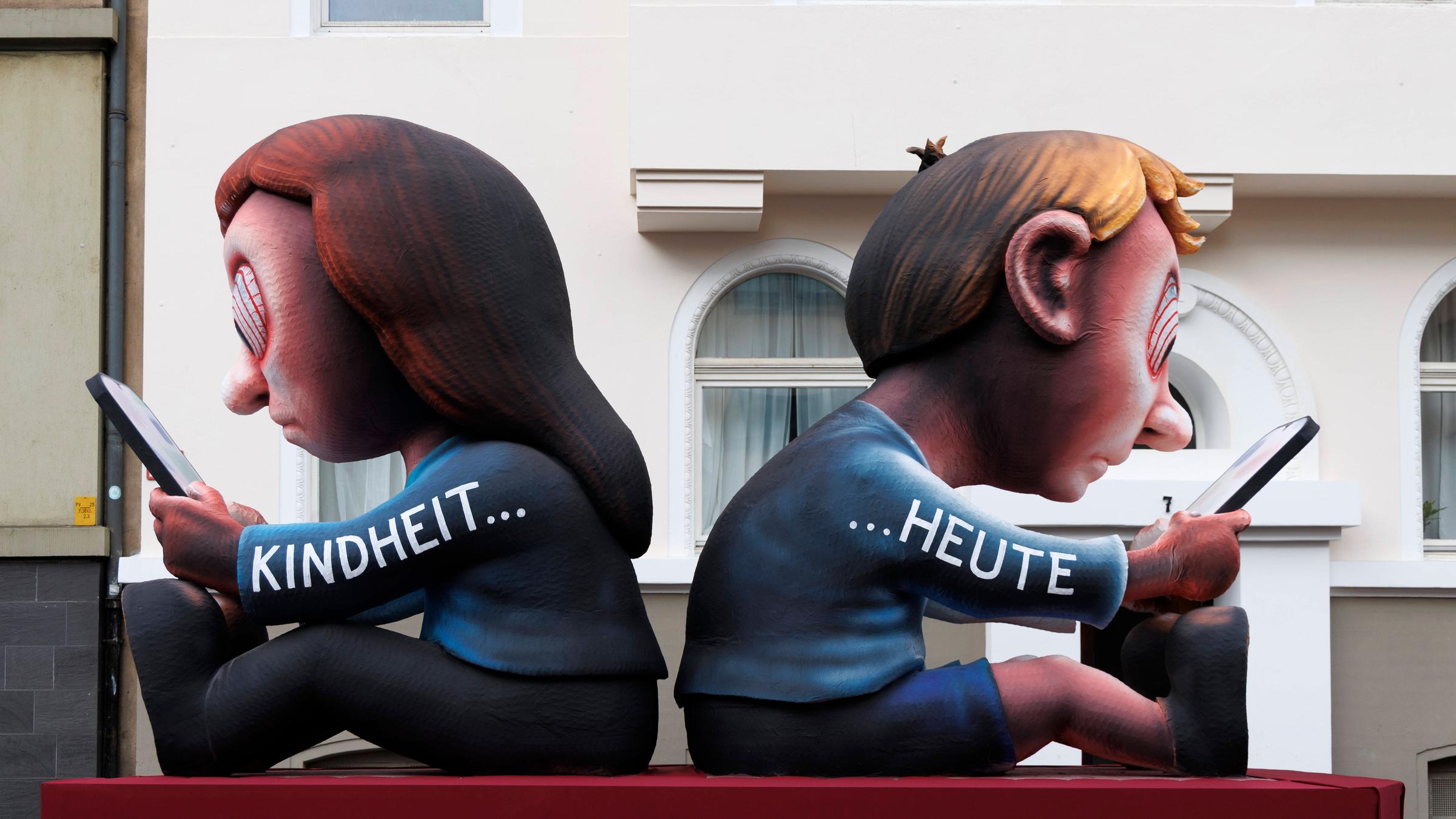 Ein Wagen vom Karnevalswagenbauer Jacques Tilly in Düsseldorf hat das Motto "Kindheit heute": Kinder, die nur auf ihre Handys starren und alles um sich herum vergessen.