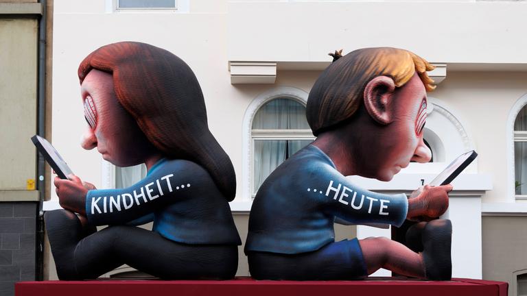 Ein Wagen vom Karnevalswagenbauer Jacques Tilly in Düsseldorf hat das Motto "Kindheit heute": Kinder, die nur auf ihre Handys starren und alles um sich herum vergessen.