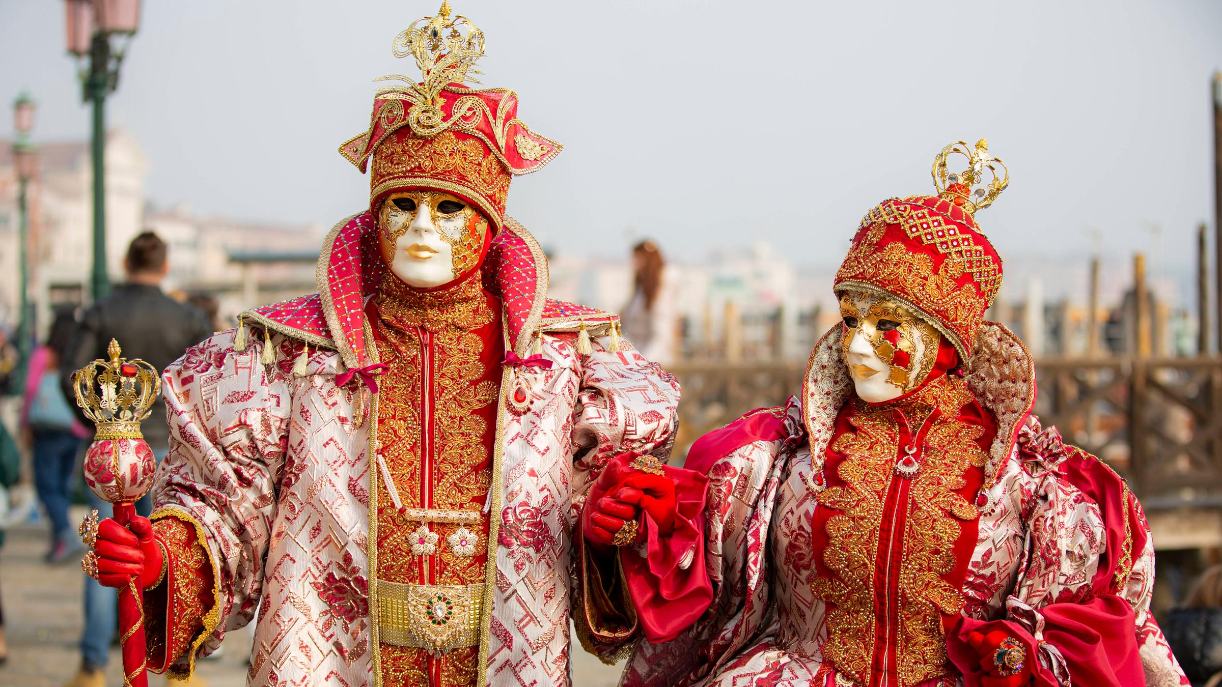 Ein Paar ist traditionell verkleidet und trägt auch traditionelle Masken.