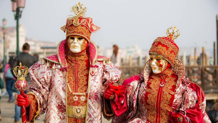 Ein Paar ist traditionell verkleidet und trägt auch traditionelle Masken.