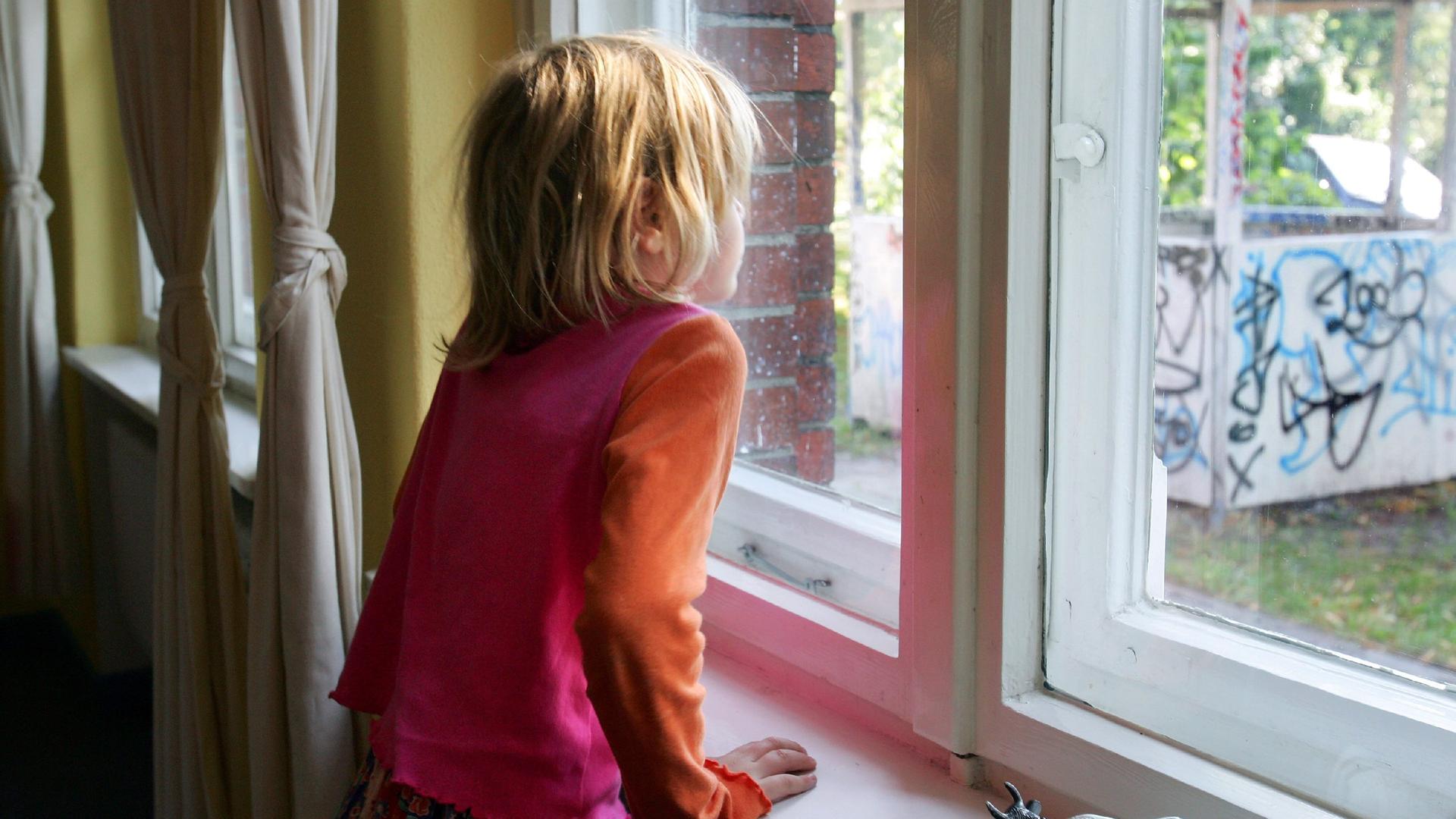 Kind schaut aus dem Fenster