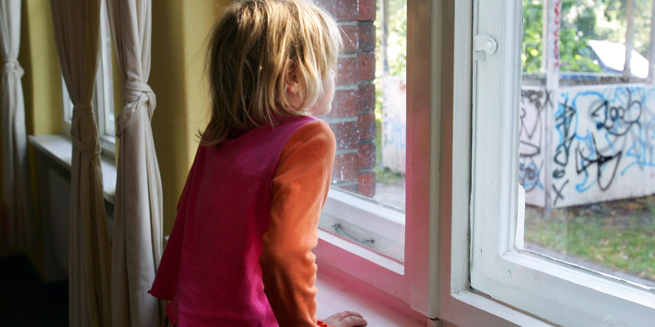 Kind schaut aus dem Fenster