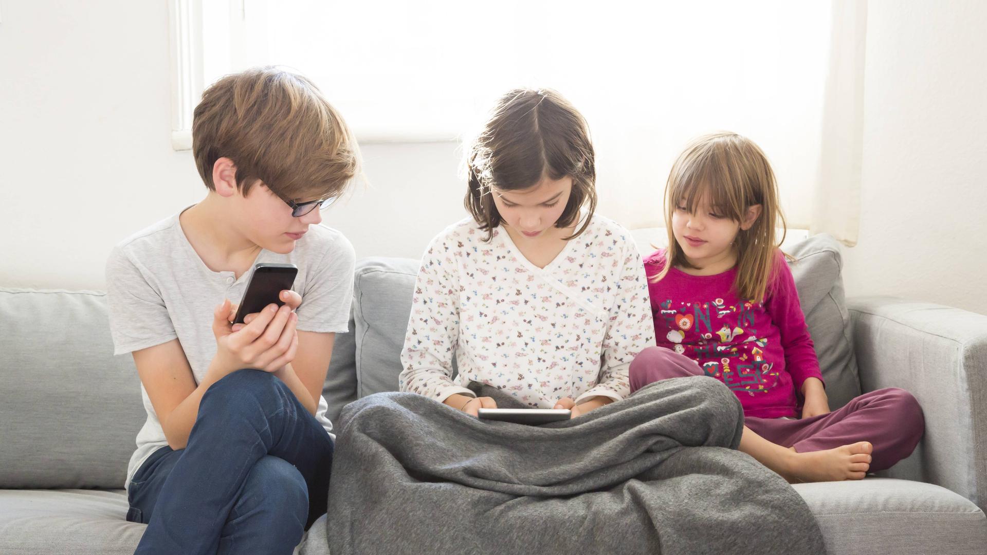 Kinder schauen auf Tablet und Smartphone