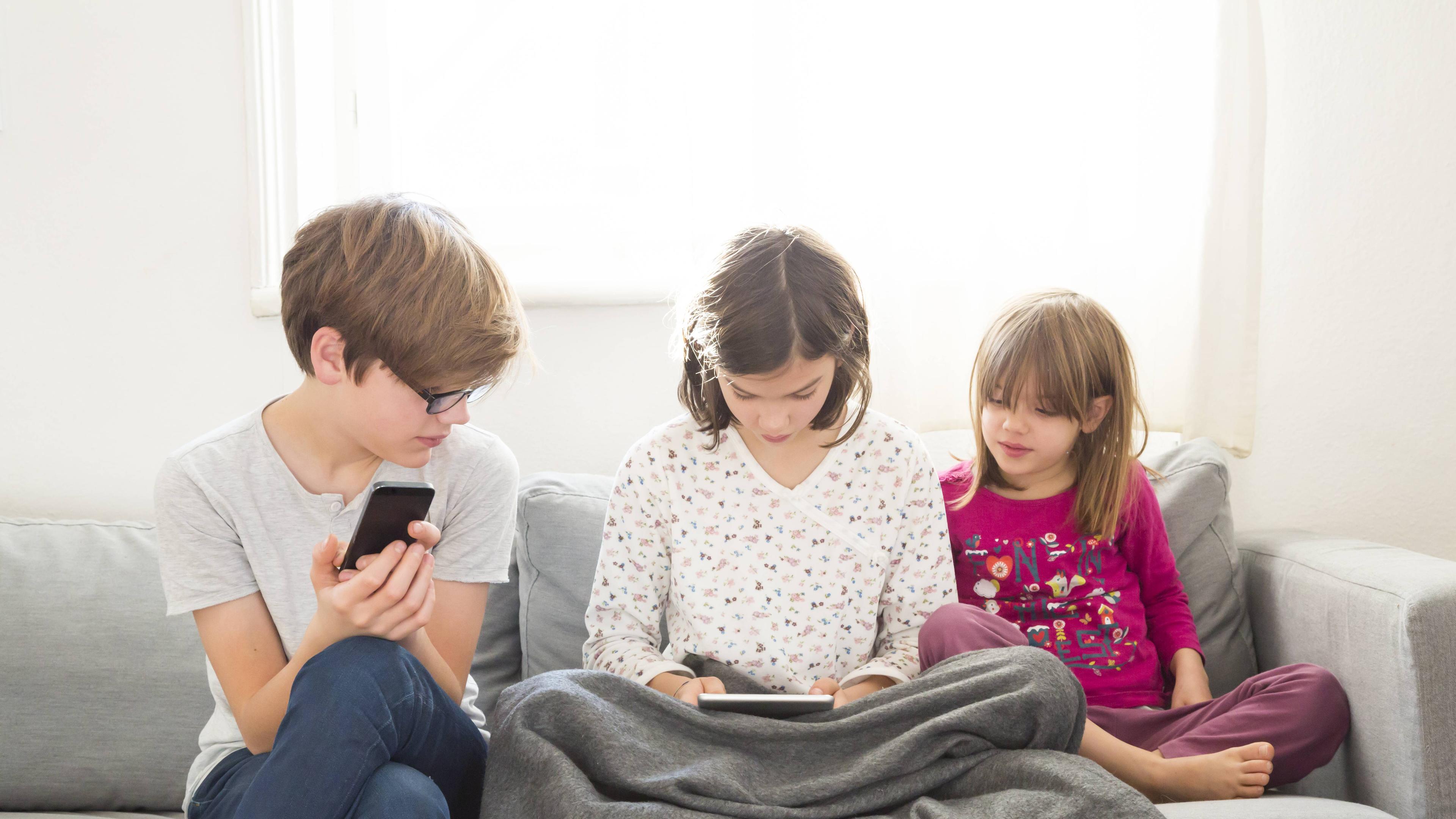 Kinder schauen auf Tablet und Smartphone