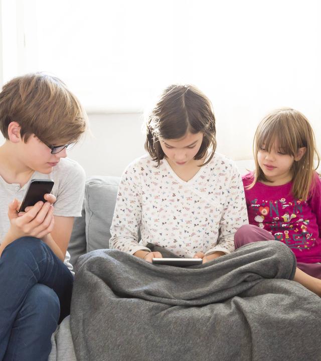 Kinder schauen auf Tablet und Smartphone