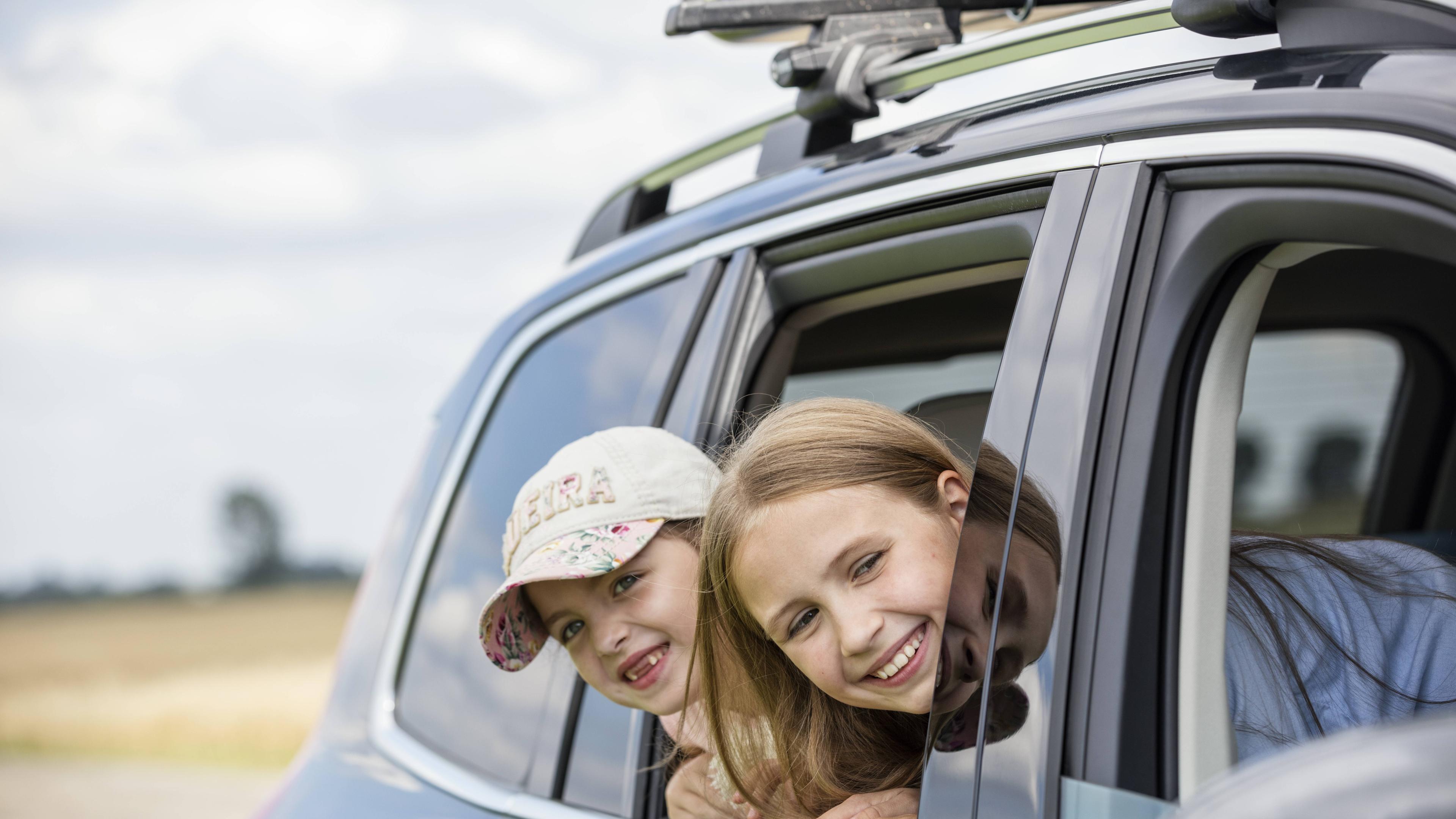 Zwei Mädchen schauen aus Autofenster