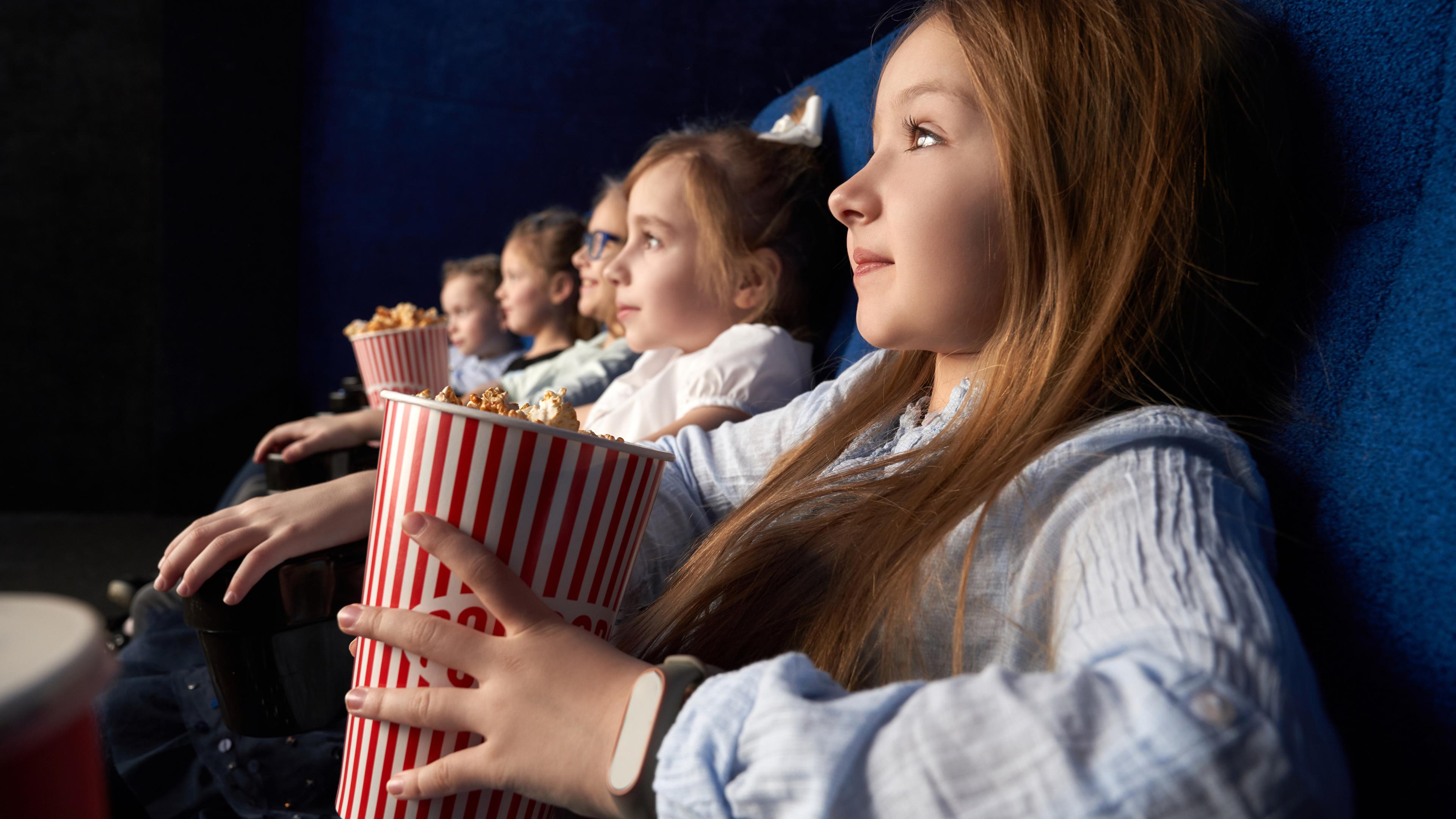 Kinder mit Popkorn im Kino