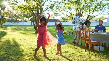 Zwei Mädchen tanzen auf Wiese