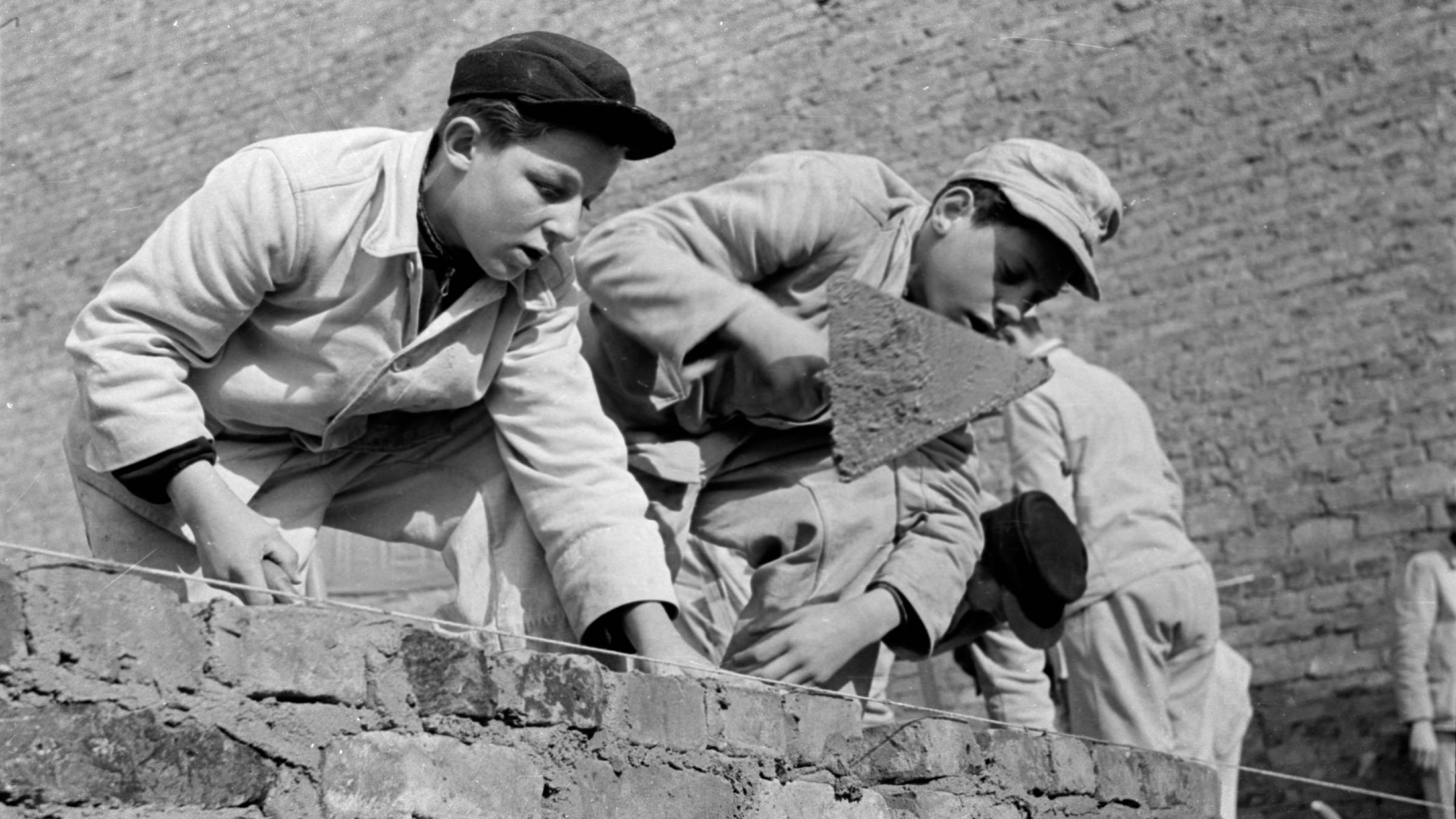 Junge Handwerker, Maurer Azubis 1953 Berlin Historisches Bild und Foto: Bauarbeiter, Kinderarbeit, Kinder, Jugendliche, Tagelöhner beim Bau, Umbau der Stalinallee im Jahr 1953 nach den Visionen des Sozialistischen Realismus bzw. der Nationalen Bautradition.