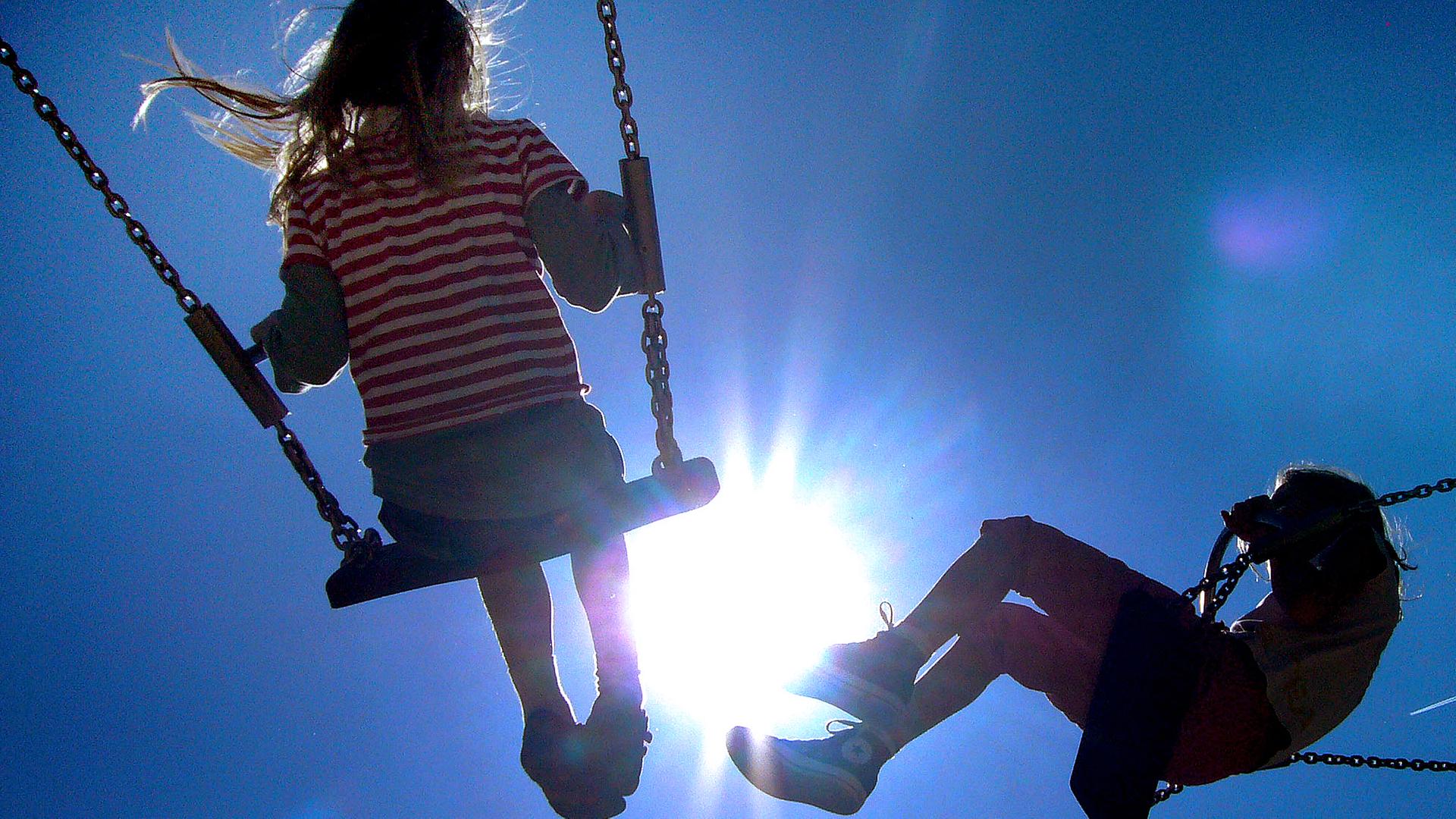 Archiv: Kinder schaukeln im Gegenlicht der Sonne, aufgenommen am 11.05.2008