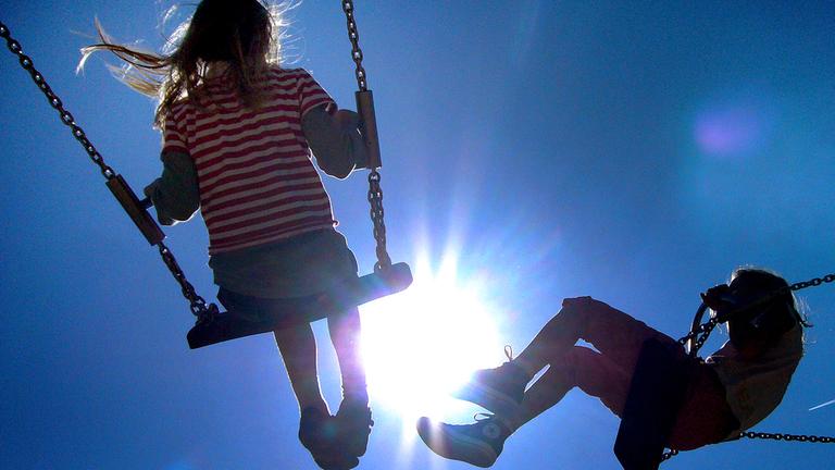 Archiv: Kinder schaukeln im Gegenlicht der Sonne, aufgenommen am 11.05.2008