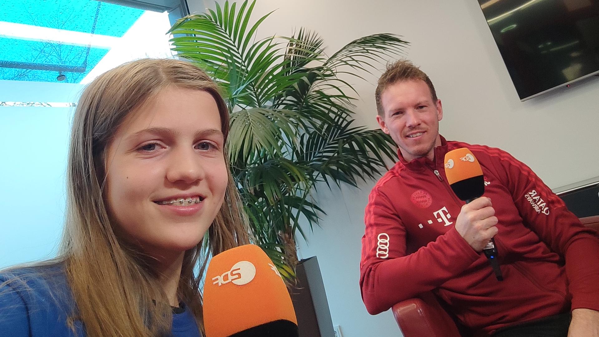logo!-Kinderreporterin Antonia und Julian Nagelsmann lächeln in die Kamera 