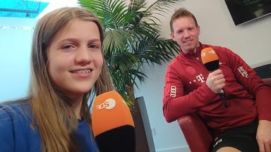 logo!-Kinderreporterin Antonia und Julian Nagelsmann lächeln in die Kamera 