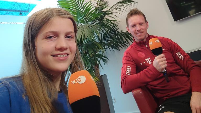 logo!-Kinderreporterin Antonia und Julian Nagelsmann lächeln in die Kamera 