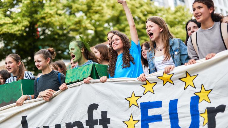 Frauen halten die Hand hoch und rufen etwas