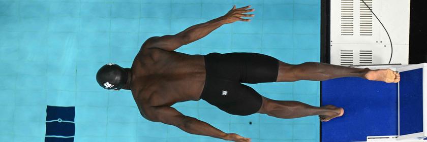 Ein Schwimmer springt ins Wasser. 