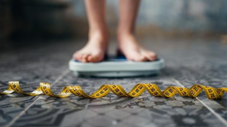 Kind steht auf Waage 