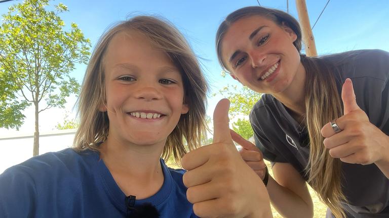 Fußballnationalspielerin Jule Brand posiert mit Kinderreporter Oskar
