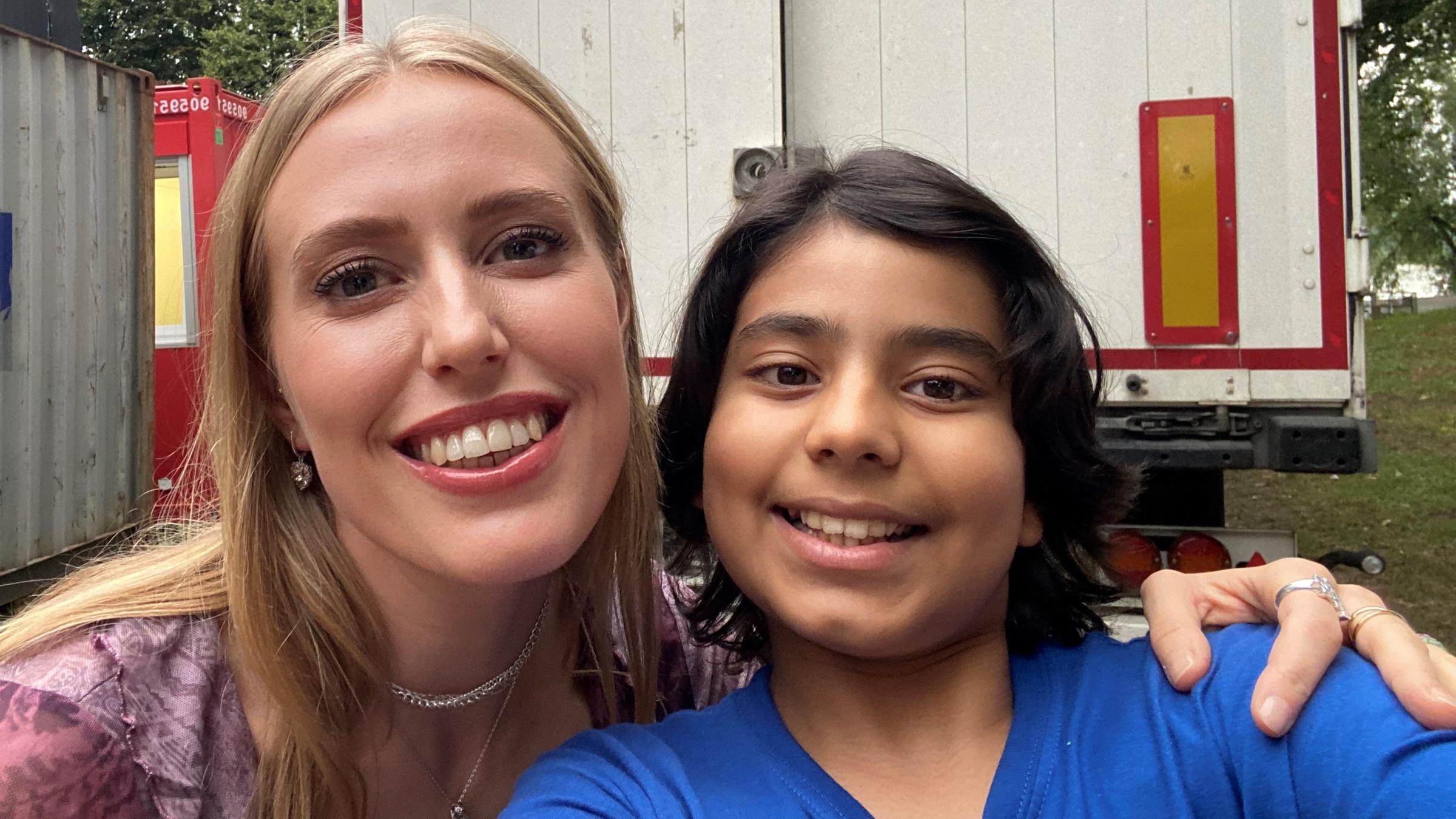 Kinderreporter Vivaan und Sängerin LEA machen ein Selfie, stehen nebeneinander und lachen in die Kamera