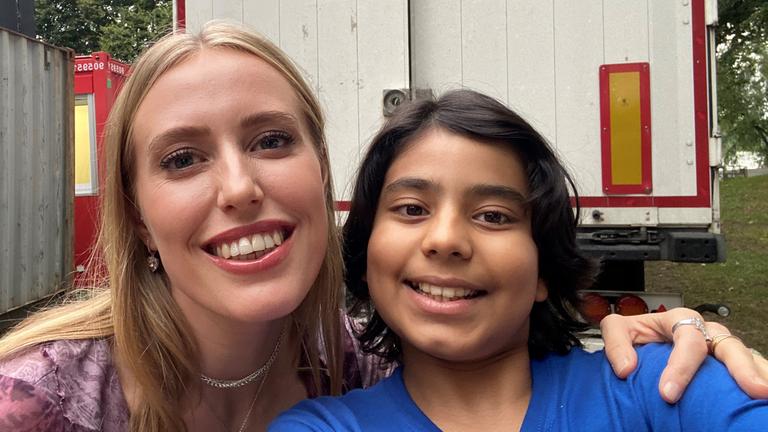 Kinderreporter Vivaan und Sängerin LEA machen ein Selfie, stehen nebeneinander und lachen in die Kamera