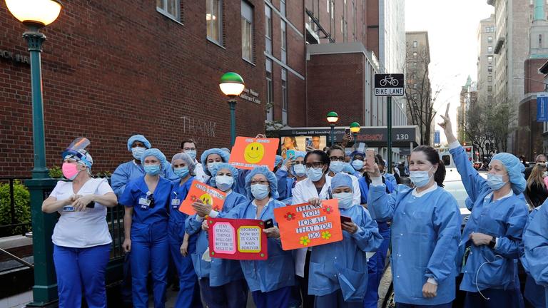 Krankenpfleger*innen und medizinisches Personal während eines Applauses für sie in New York City. 