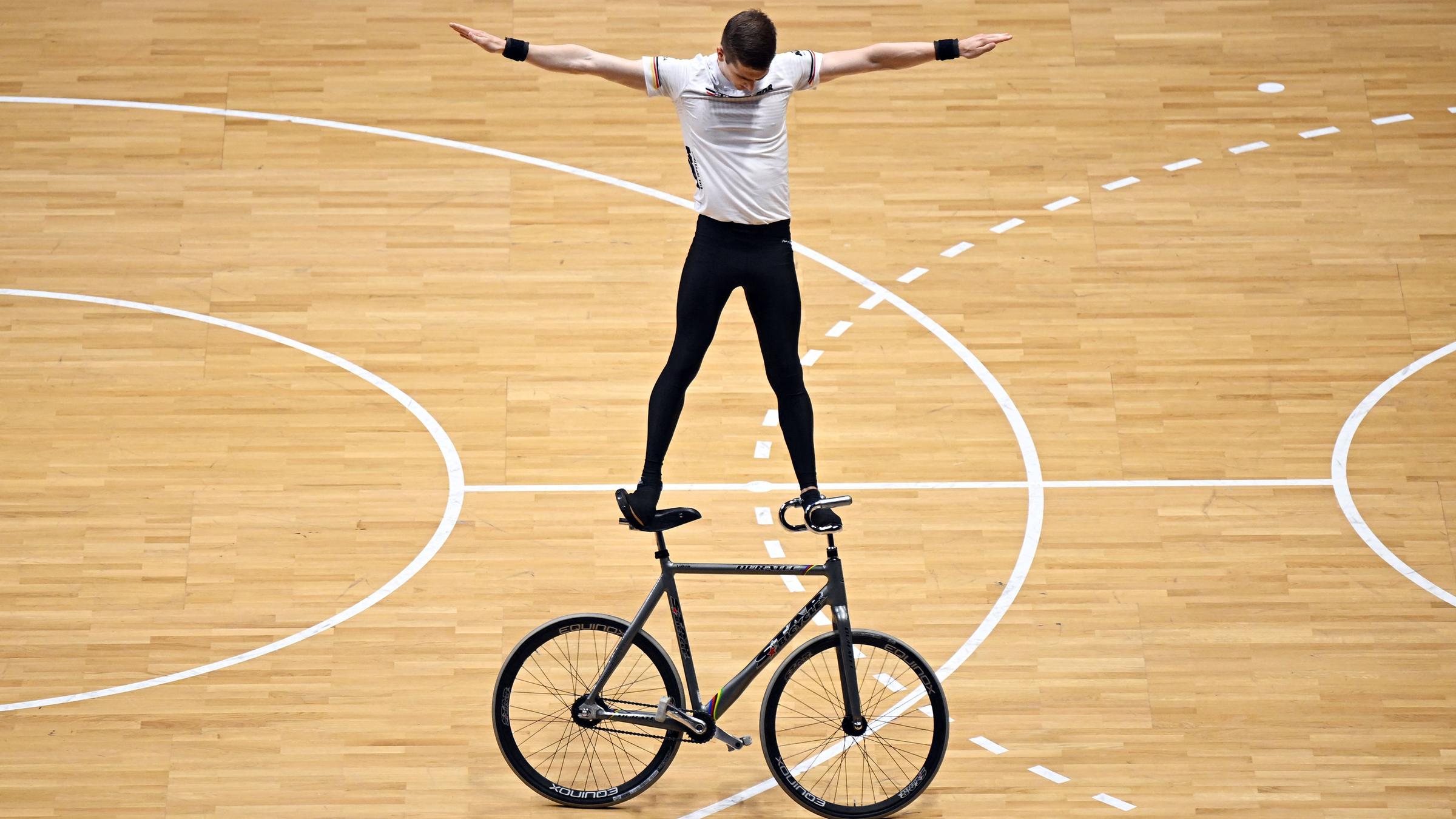 Ein mann steht auf einem Kunstrad und führt eine Kür auf