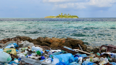 Kunststoffmüll im Meer vor einer Insel