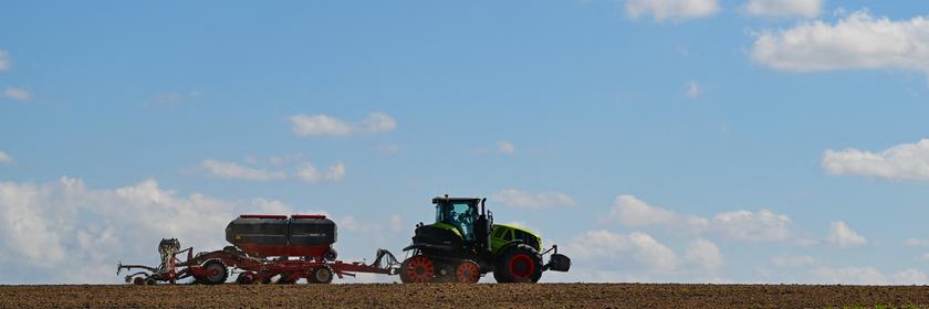 Traktor fährt über ein Feld.