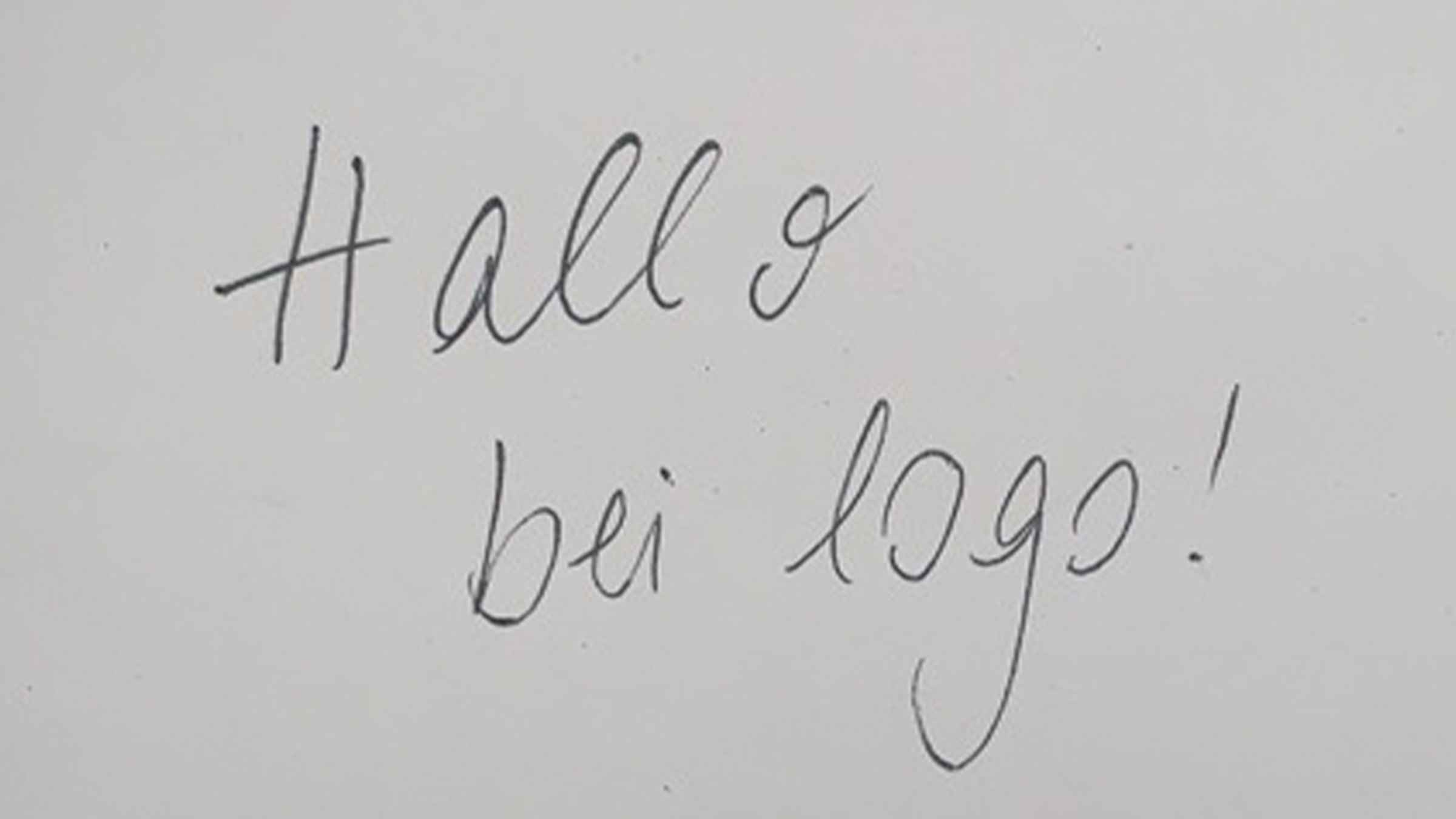 Weißer Zettel mit Handschrift "Hallo bei logo!"