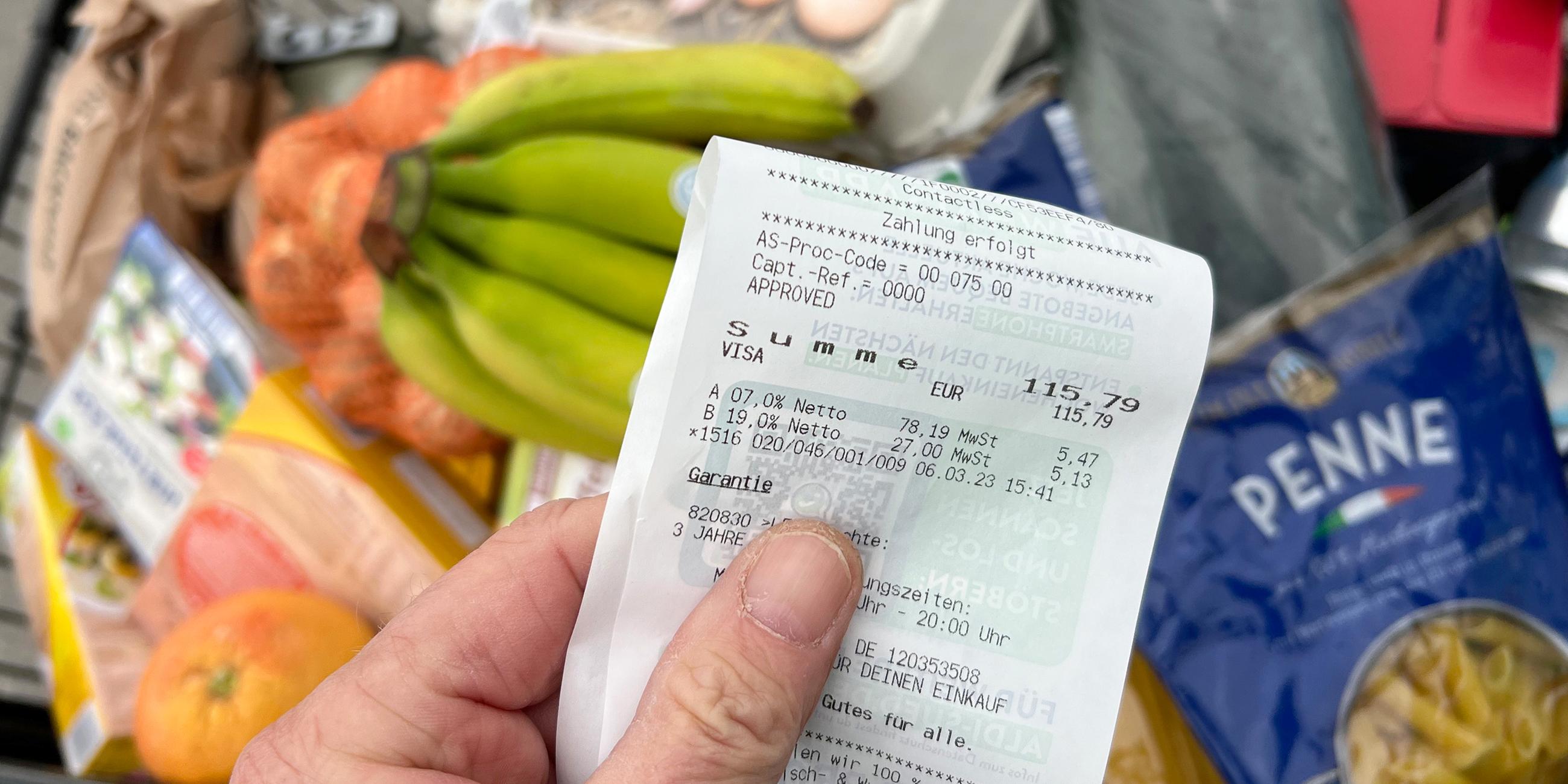 Mann kontrolliert Kassenzettel vor dem Einkaufswagen