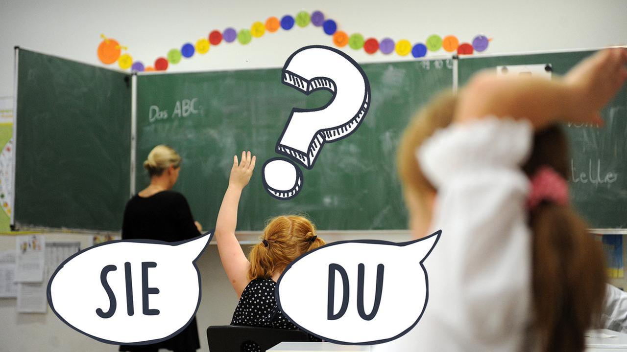 Lehrerin steht an der Tafel, Schülerin meldet sich.