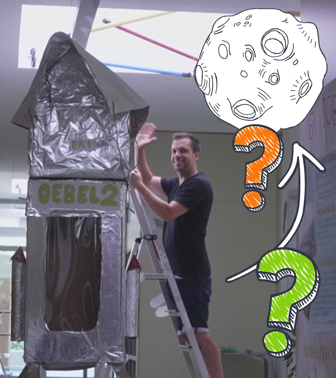 EIn Lehrer steht auf einer Leiter neben einer Rakete, die aus Pappe gebaut ist. Auf em Bild sind noch Doodles: ein Pfeil, der auf einen Mond zeigt und daneben zwei Fragezeichen.