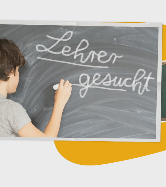 Lehrer schreibt auf Tafel "Lehrer gesucht