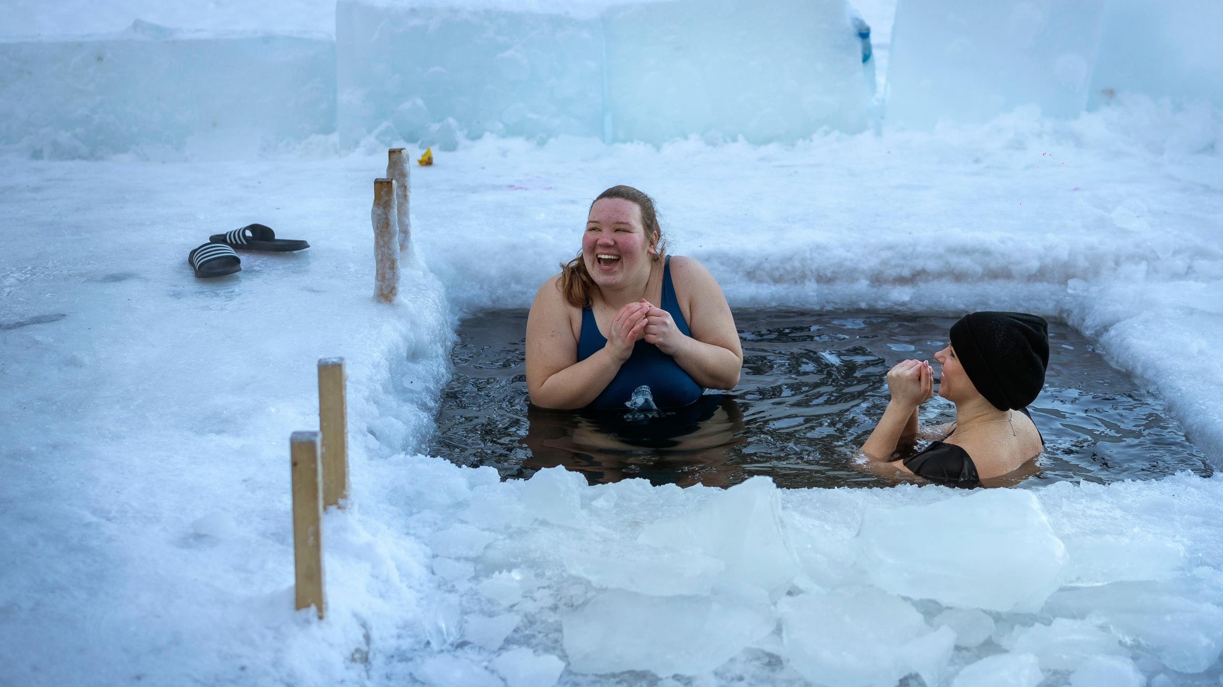Frauen baden in einem Eisloch in einem See in der Nähe von Vilnius bei Temperaturen von -27 Grad Celsius.