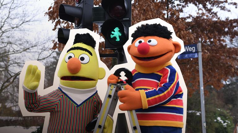 Ernie und Bert stehen vor einer Ampel für die Sesamstrasse