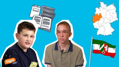 Zwei Jungs sitzen neben einer Deutschlandkarte und der Flagge von NRW. Hinter ihnen sieht man einen Stapel Bücher.