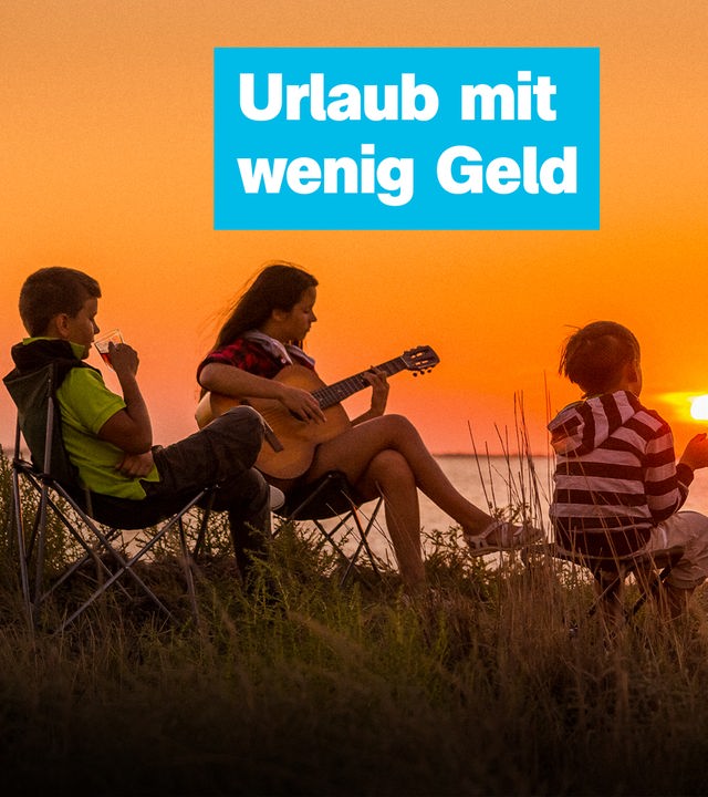 Drei Kinder sitzen vor einem orangenen Sonnenuntergang zusammen, ein Kind trinkt etwas aus einem Glas, ein anderes spielt Gitarre und das dritte sitzt in der Hocke, darauf steht: Urlaub mit wenig Geld.