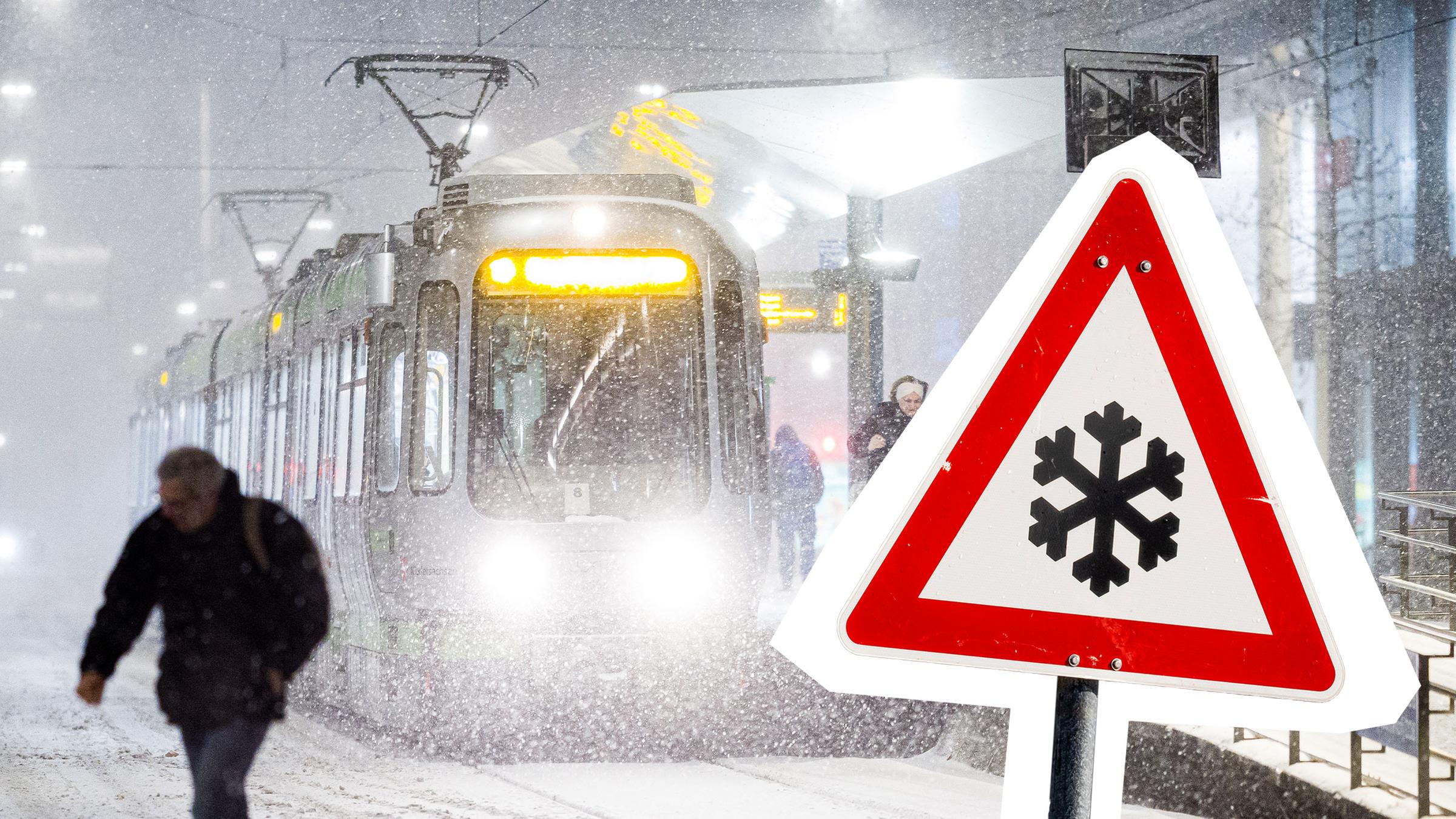  Eine Straßenbahn hält am frühen Morgen im dichten Schneefall an einer Haltestelle daneben ist ein Warnschild mit einer Schneeflocke