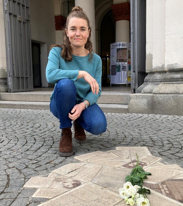 Lotte kniet vor Flugblättern der Weißen Rose