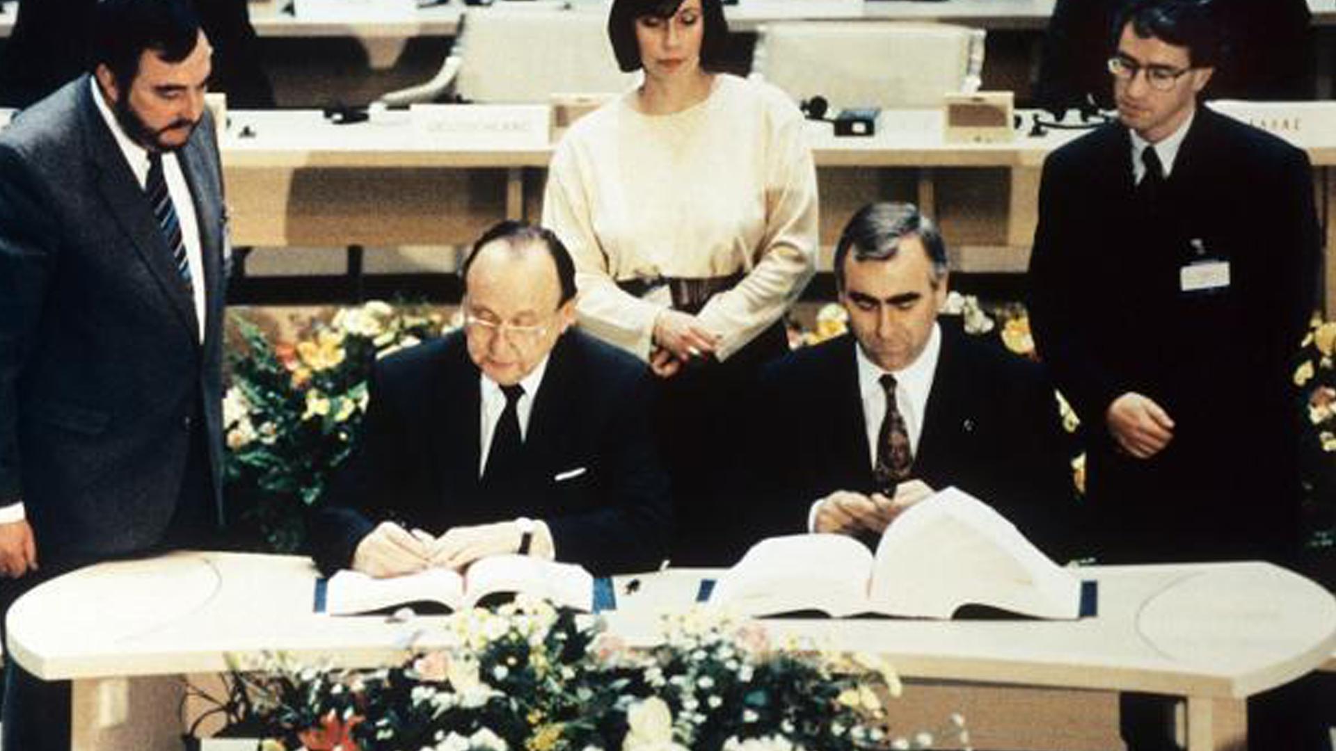 Bundesaussenminister Hans-Dietrich Genscher (l) und Bundesfinanzminster Theo Waigel (r) unterzeichnen am 7. Februar 1992 den Vertrag zur Wirtschafts- und Währungsunion der Europäischen Gemeinschaft in Maastricht (Niederlande). 